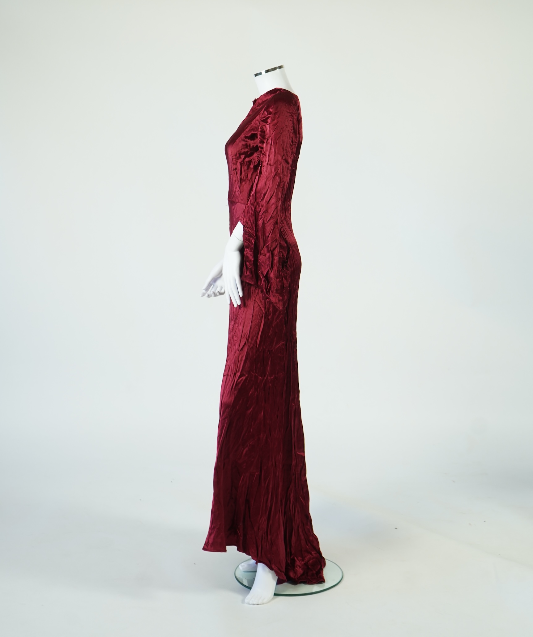 A 1920’s light green silk evening cape with hand batik borders and label: Tito de Canival Mode, together with a navy ladies two piece suit and a maroon satin evening dress. Cape 100cm long. Condition - cape good, navy tw
